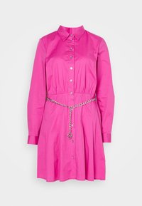 Abito camicia fucsia in cotone con maniche lunghe, chiusura a bottoni e vita stretta. Presenta una cintura in catena argentata con un elemento decorativo circolare.