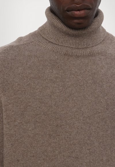 Bruine geribbelde turtleneck trui van gebreide stof, met een hoge kraag en een gebroken uiterlijk met een subtiel patroon.