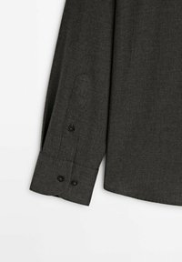 Czarna, długa koszulka z długim rękawem, z teksturowanej tkaniny, zapinanymi mankietami na dwa guziki oraz eleganckim, dopasowanym krojem.