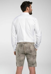 Witte herenbloes met lange mouwen en knoopmanchetten, gecombineerd met grijze suède shorts tot de knie met gedetailleerde stiksels en zijzakken.