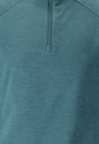 Teal, kevyt fleece-pullover, jossa on puoliveto ja sileä rakenne. Mukana pystykaulus ja vahvistetut saumat kestävyydelle.