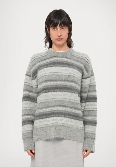 Pull à rayures grises en tissu doux et duveteux. Possède un col rond, des épaules tombantes et une coupe légèrement ample, avec des largeurs de rayures variées.