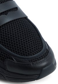 Sneaker nera con tomaia in mesh e accenti in pelle sintetica. Presenta un colletto imbottito, una superficie testurizzata e una forma sagomata.