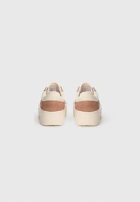 Sneakers marroni e crema con tomaia in camoscio, suola spessa color crema e lacci rotondi, visti dal retro.