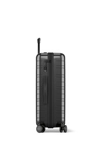 Black hard-shell suitcase features a textured surface, retractable handle, four wheels, and a built-in combination lock.