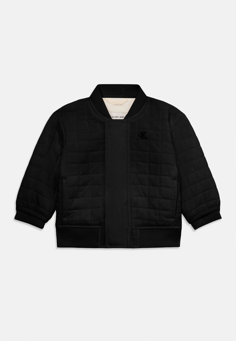 Melna pūkota bomber tipa jaka ar ribota auduma apkakli, aprocēm un apakšmalu, uz krūtīm neliels Calvin Klein logotips.