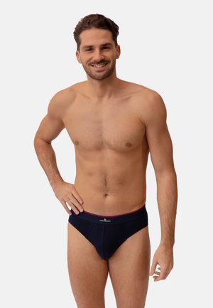 Culotte bleue marine avec une taille douce et un accent rouge. Le tissu semble légèrement texturé, conçu pour le confort.