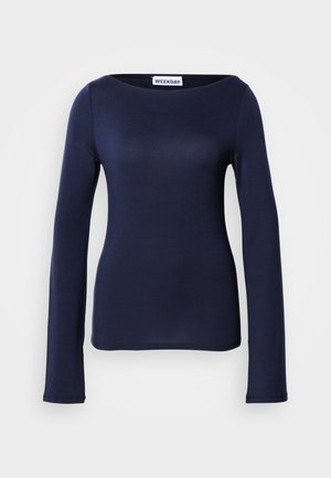 Long-sleeve navy blue top made of soft, stretchy fabric with a boat neckline and fitted silhouette. Tag label reads "WEEKDAY."