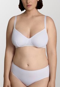 Bra wireless bianco in tessuto morbido, con spalline regolabili e design senza cuciture. Abbinato a mutande bianche senza cuciture coordinate.