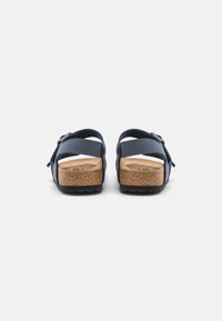 Mørkeblå sandaler med korksåle, justerbar stropp og teksturert gummisåle. Åpen bakdesign for pusteevne og komfort.