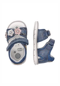 Sandales en denim avec des accents floraux en rose et blanc, intérieur gris et blanc, brides à boucle et semelle en caoutchouc blanche.