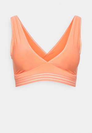 Peach-colored bralette with a deep V-neck, soft texture, and white horizontal stripes near the band. Racerback design for added support.