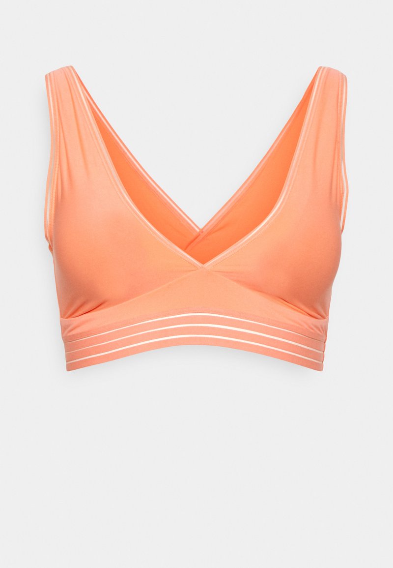 Bralette em tom pêssego com um decote em V profundo, textura suave e riscas horizontais brancas perto da faixa. Design às costas em formato de corrida para maior suporte.