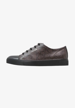 Baskets Calvin Klein profil bas gris foncé avec semelle en caoutchouc noire, bout noir, lacets noirs et motif de logo subtilement embossé.