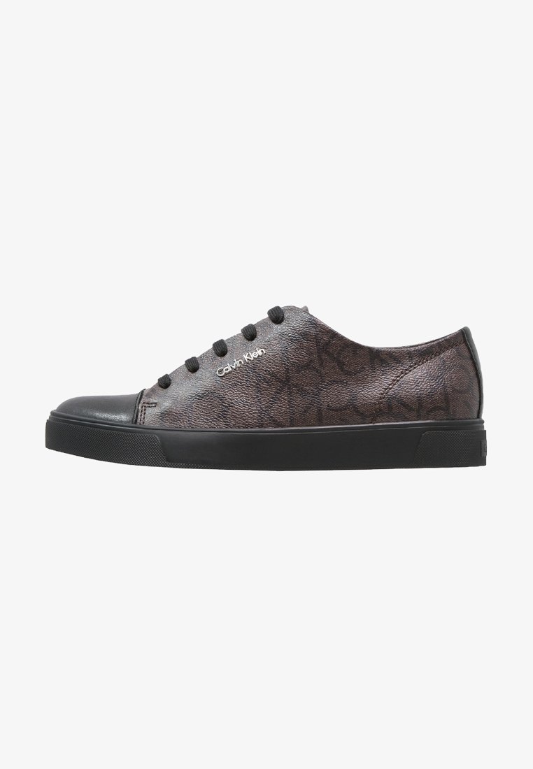 Baskets Calvin Klein profil bas gris foncé avec semelle en caoutchouc noire, bout noir, lacets noirs et motif de logo subtilement embossé.