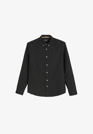 Czarna koszula z długim rękawem zapinana na guziki, wykonana z bawełny. Posiada klasyczny kołnierzyk, białe guziki oraz subtelne logo na piersi.