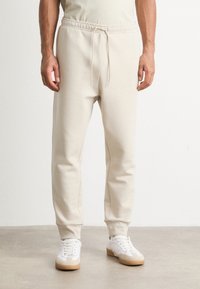 BOSS HADIKO - Spodnji deli trenirk - light beige