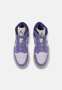 Paire de baskets montantes Air Jordan violettes et blanches vues de dessus sur un fond blanc.