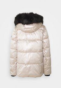 Kurtka puchowa w jasnym beżu o błyszczącej teksturze, z czarnym kapturem wyłożonym futrem i prążkowanymi mankietami. Poziomy pikowany wzór.