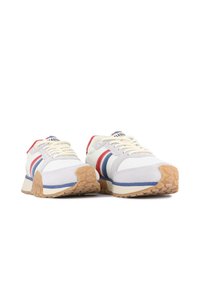 Sneakers z białą górą z tkaniny, szarymi zamszowymi akcentami, czerwonymi i niebieskimi paskami oraz gumową podeszwą. Posiadają płaskie sznurowadła i wyściełany język.