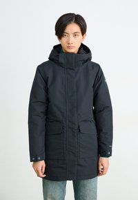 Melnā garā jaka ar kapuci, divām priekšējām kabatām, ar rāvējslēdzēju un gludu tekstūru. Slim fit dizains ar minimāliem akcentiem.