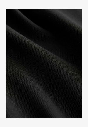 Čierna textúrovaná tkanina s tkaným vzorom, zobrazuje jemné záhyby a záhyby, čo zdôrazňuje jej hladký a rovnomerný povrch.