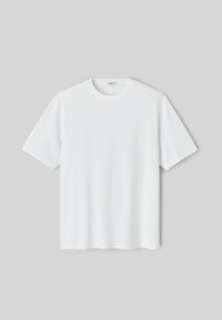 T-shirt blanc uni à manches courtes et col rond, posé à plat sur fond gris clair.