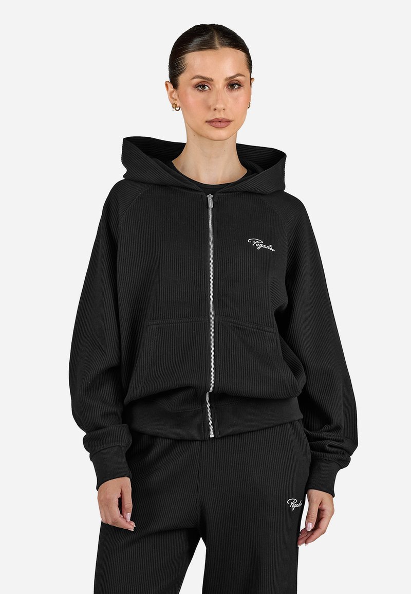 Čierna rebrovaná mikina na zips s veľkou kapucňou, prednými vreckami a malým bielym logom. Má voľné rukávy a uvoľnený strih.