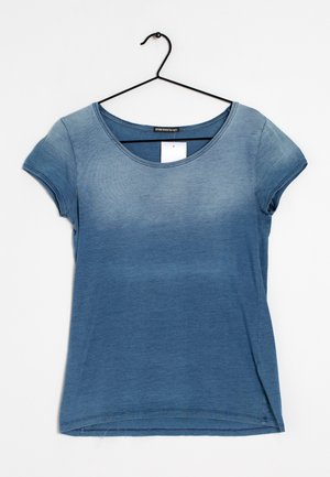 Kurzärmeliges T-Shirt mit blauem Farbverlauf, das an einem schwarzen Kleiderbügel vor weißem Hintergrund hängt.