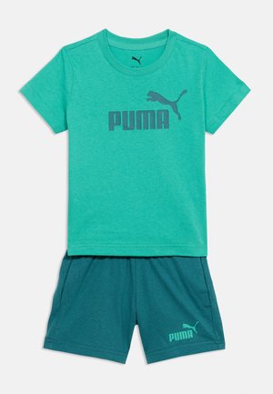 Maglietta verde a maniche corte con logo Puma e pantaloncini verde scuro abbinati con piccolo logo Puma sulla gamba sinistra.