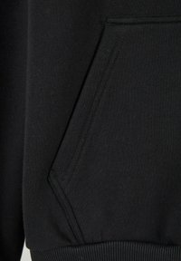 Felpa nera con cappuccio, dotata di tasca a marsupio, polsini a costine e tessuto morbido e texture. La cucitura è pulita e uniforme in tutto il capo.