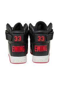 Zapatillas de baloncesto altas negras con acentos rojos. Presentan un exterior de cuero texturizado, correa ajustable y un audaz logo "33" y "EWING" en los talones.