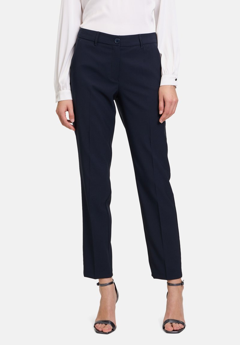 Pantaloni tailored color navy con un design elegante a gamba dritta, tasche laterali e chiusura a bottone. Realizzati in un tessuto morbido con una leggera trama.