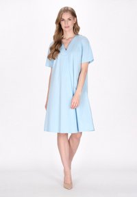 Hellblaues kurzärmeliges Kleid mit V-Ausschnitt, lockerer Passform und fließender Form. Glatte Textur, fällt über das Knie, minimalistische Designdetails.