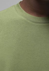 Lichtgroen kortemouwen shirt met een ronde hals, met een gladde, gestructureerde stof en een eenvoudige constructie zonder enige patronen of accenten.