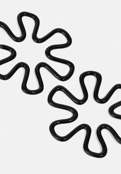 Zwei schwarze Haarklammern mit einem gewellten, blütenähnlichen Design. Hergestellt aus glänzendem Material, das flexible, verspielte Formen mit glatten Texturen betont.