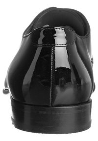 Schwarze Lacklederschuhe mit einer glatten, glänzenden Oberfläche, abgerundeter Spitze und niedrigem Absatz. Verfügt über eine saubere Naht, die entlang der Rückseite verläuft.