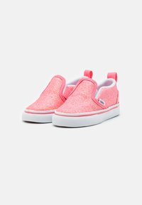 Zapatos sin cordones de lentejuelas rosas con paneles laterales elásticos, suelas de goma blanca y una pequeña lengüeta trasera para facilitar el uso.