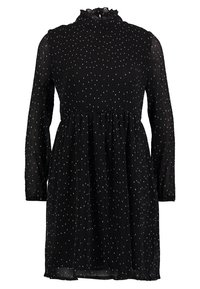 Black dress with long sleeves and high neck; features a pleated design and white dot pattern throughout. Soft, lightweight fabric.