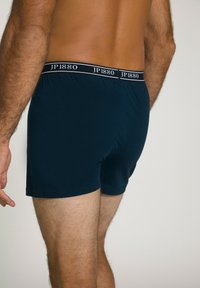 Navyblaue Baumwollboxershorts mit einer glatten Textur, ausgestattet mit einem schwarzen Bund mit dem weißen Branding "JP1880".