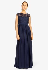 Mørkeblå aftenkjole med blondetop, korte ærmer, plisseret nederdel og tætsiddende talje. Glat stof, elegant tekstur og detaljerede blomster mønstre.