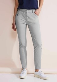Pantalones slim-fit de color gris claro con un diseño clásico de cinco bolsillos, que cuentan con bolsillos frontales, cierre de botón y una textura lisa.
