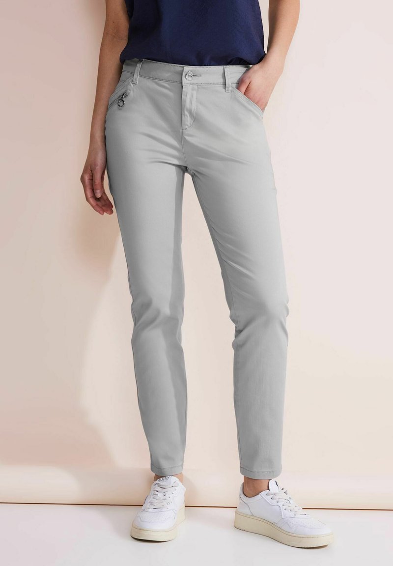 Pantalones slim-fit de color gris claro con un diseño clásico de cinco bolsillos, que cuentan con bolsillos frontales, cierre de botón y una textura lisa.