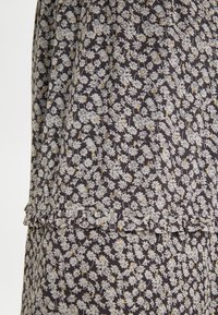 Bloemige jurk met een donkere achtergrond, versierd met kleine witte en gouden bloemen. Zachte stof met een gerimpelde zoom en delicate afwerking.