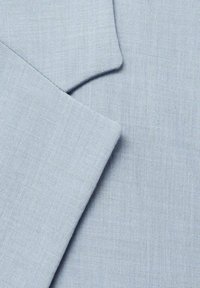 Jasnoniebieska tkanina o teksturowanym splocie, z gładkimi brzegami i wyraźnym wykończeniem. Materiał wykazuje subtelne różnice w odcieniach.