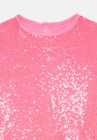 Rosa Paillettenbluse mit einem glatten Halsauschnitt und einer strukturierten Oberfläche, die mit glitzernden Pailletten in verschiedenen Größen geschmückt ist.