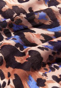 Tkanina se vzorem leopardí kůže v odstínech hnědé, černé a modré. Textura je hladká s lehkým a jemně plynoucím vzhledem.