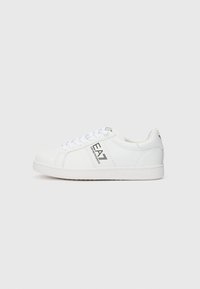Adidași albi din material sintetic neted, cu un design clasic cu șireturi, branding embossat și o talpă din cauciuc texturată.