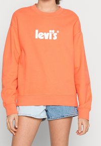 Sudadera naranja de mezcla de algodón, con cuello redondo, mangas largas y el logo blanco de "levi's" centrado en la parte delantera.