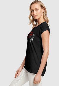 Black short-sleeve T-shirt with a crew neck, featuring red and white text and graphic print on the front. Smooth cotton texture.